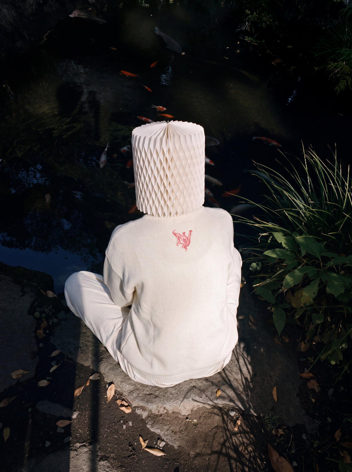 Model wearing Hitodama Knit (Akane), back view beside a pond