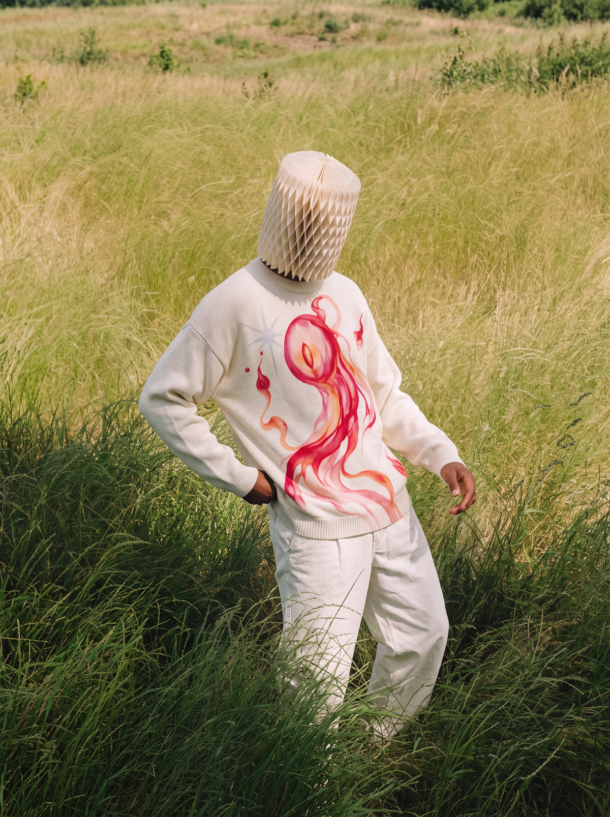 Model wearing Hitodama Knit (Akane), front view in a grassy field